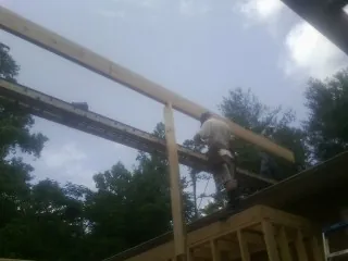 Carpenter setting a ridge beam over a new addition frame — Ice Dam Removal by Roofing Brothers in Unicoi