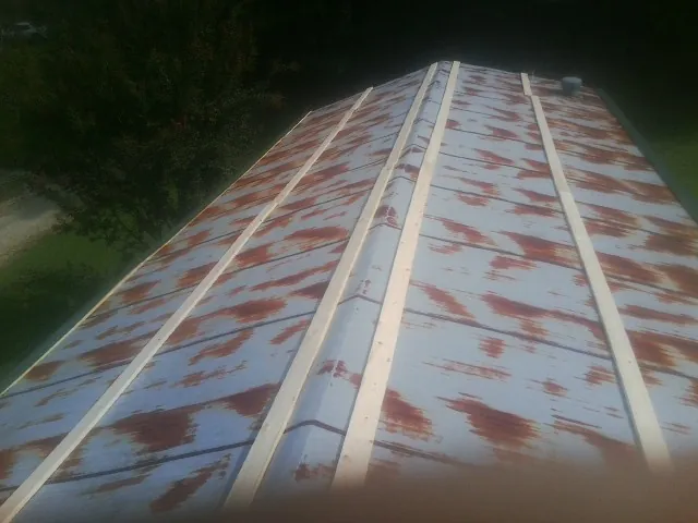 Rusted metal roof panels with new wood purlins before replacement — Storm Damage Roof Repair in Unicoi by Roofing Brothers